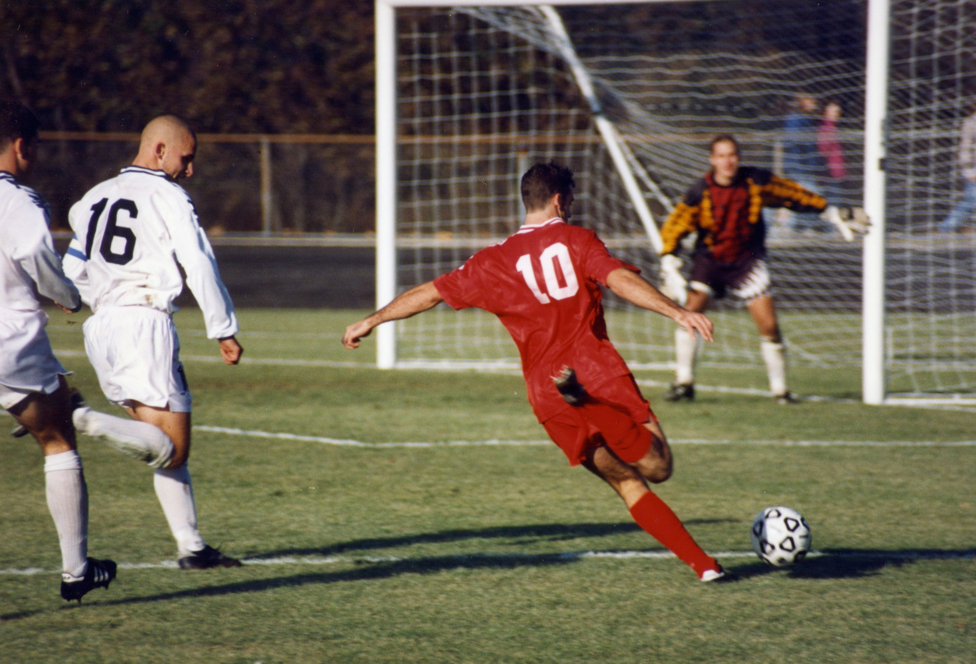 this shows a man kicking a soccer ball.